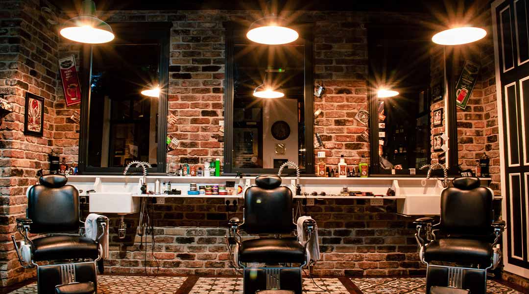 black leather barber chair near brown brick wall